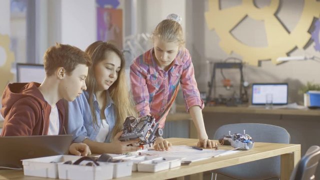 Two Girls and a Boy Work on Science Class Robotics Project. They're Building Moving Robot from Constructor. Shot on RED EPIC-W 8K Helium Cinema Camera.