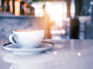 a cup of coffee on wood table . Simple breakfast or coffee break in morning/ selective focus.blank seating  indoor in urban cafe. color filter effect