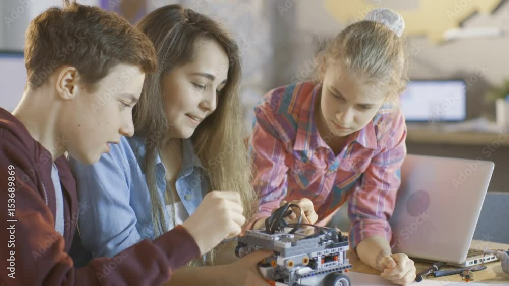 Poster two girls and a boy program robot for school science class project. shot on red epic-w 8k helium cin