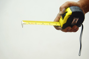 hand holding measuring tape over white background