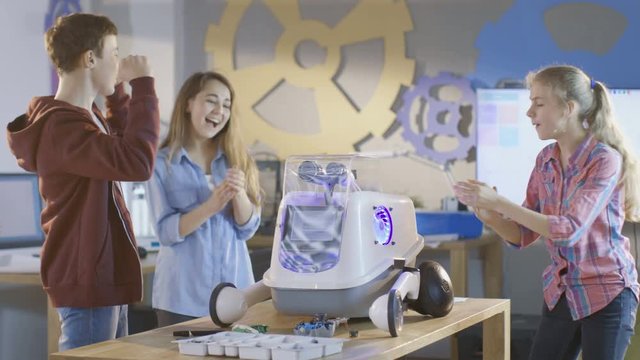 Two Girls and a Boy Turn On Fully Functional Programmed Robot with Bright LED Lights for  School Science Class Project. Shot on RED EPIC-W 8K Helium Cinema Camera.