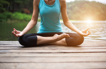 Healthy woman practicing yoga on the bridge in the nature..
