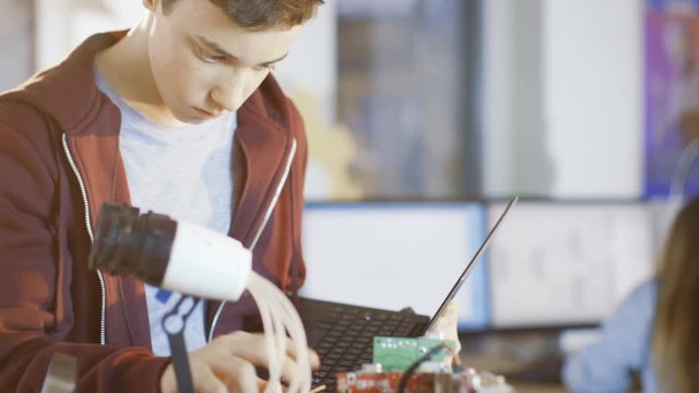 Boy Builds Fully Functional Robot with Bright LED Lights and Programs it with Laptop for His School Robotics Club Project. Shot on RED EPIC-W 8K Helium Cinema Camera.