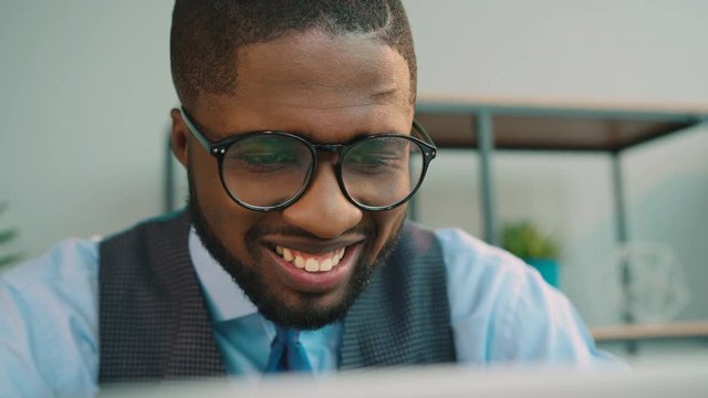 African american business man using laptop computer at the office. Black office worker typing on laptop keyboard and looking at the screen monitor. Close up