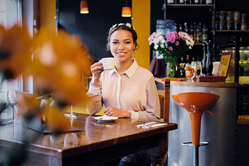 Female drinks coffee in a cafe.