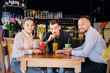 Friends drinking coctails in a cafe.