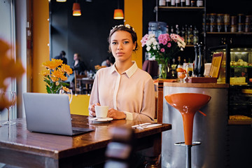 Female drinks coffee in a cafe.