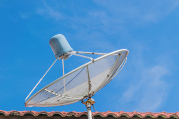 Abstract soft blurred and soft focus of the old analog satellite on the roof with the blue sky cloud and copy space background.