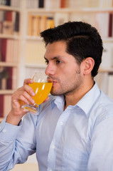 Fototapeta premium Handsome man drinking a glass of vitamin C dissolved