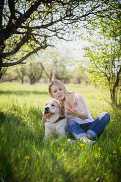 The girl makes selfie with a labrador