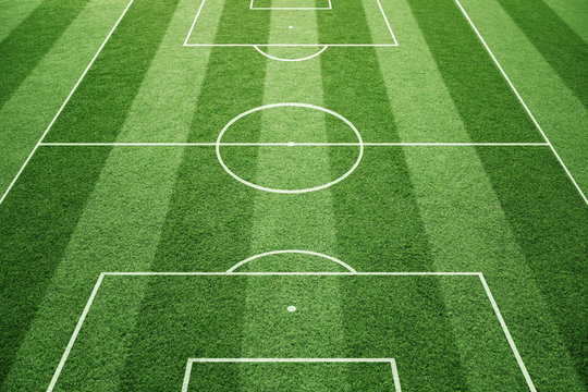 Soccer play field ground lines on sunny grass pattern background. Goal side perspective used.