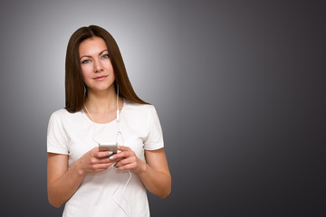 Beautiful attractive casual young woman talking on her mobile phone. Studio shot over gray background.