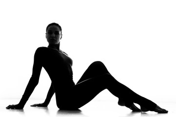 Elegant woman. Silhouette of a graceful sport woman sitting posing gracefully