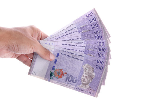 Isolated hand holding some 100 Malaysian Ringgit