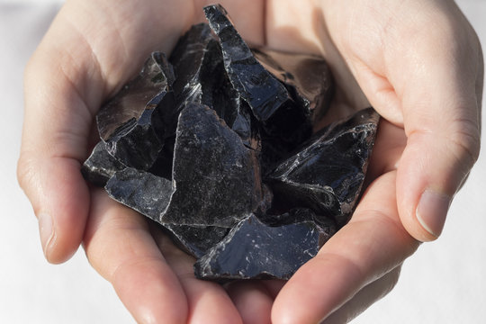 Black Obsidian pieces in hands