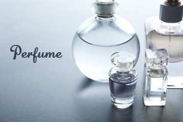 Bottles of perfume and text on gray background
