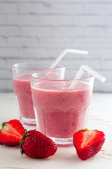 Iced strawberry pink cocktail in a glass and strawberries