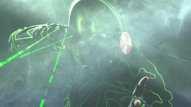 Cyborg man show with laser. Man in mirror costume in clouds of smoke in darkness