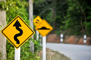 Traffic alerts downhill slope. Reduce speed and use a lower gear, Curvy road sign to the mountain in rural area