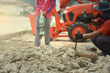 Obraz premium Builder Builder with pneumatic hammer drill equipment breaking asphalt at road