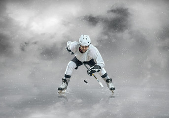 Ice hockey player in sport action on the ice under sky
