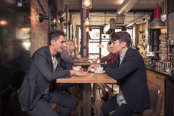 four people talking, small group of people talking, coffee shop indoors