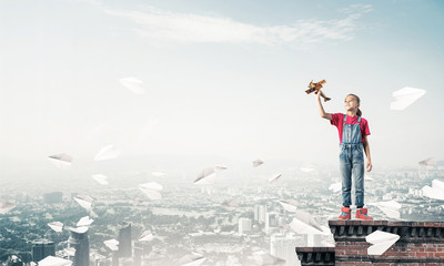 Fototapeta premium Concept of careless happy childhood with girl dreaming to become