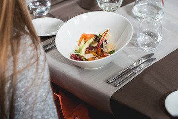 woman is preparing to eat delicious salmon salad in a restaurant. small portion