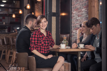 small group of people, sitting, coffee shop table, woman looking to the camera