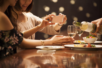 Women are taking photos of wine at the bar