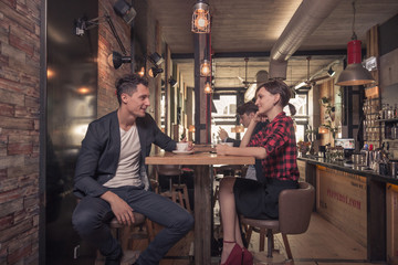 two young people, couple talking happy, coffee shop indoors