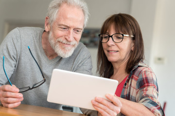 Modern mature couple using tablet