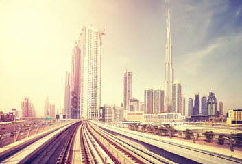 Fototapeta na wymiar Dubai modern downtown seen from metro train, color toning applied, United Arab Emirates.
