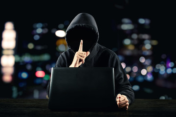 Hacker in front of his computer. Dark face