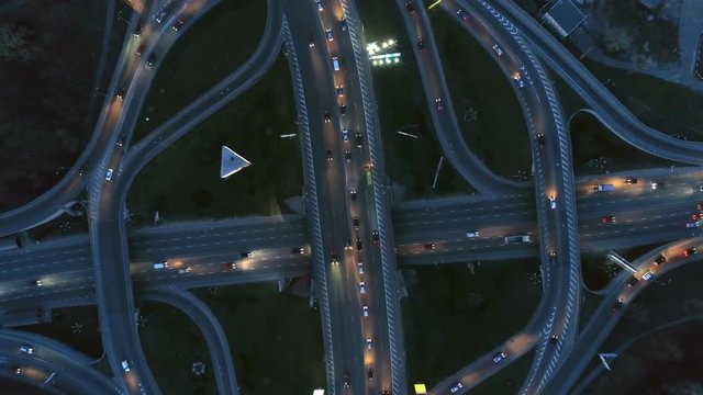 Vertical top down aerial view of traffic on freeway interchange at night