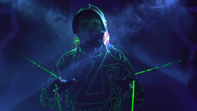 Humanoid man robot with laser weapon in clouds of smoke in darkness.