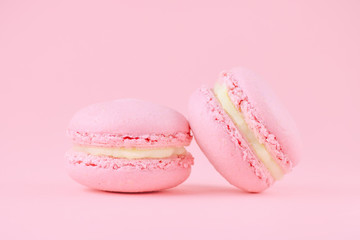 two pink macaroons homemade, on pink background, selective focus
