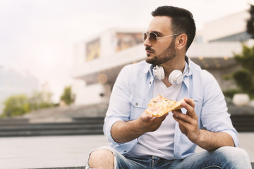 Young man eating pizza