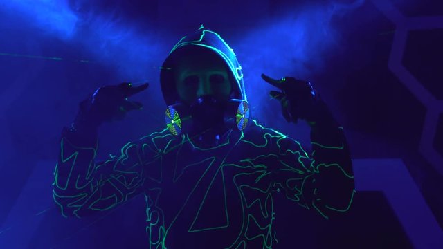 Humanoid man robot with laser weapon in clouds of smoke in darkness.