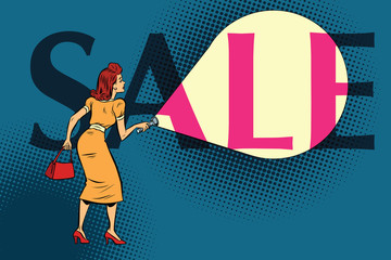 Woman shining a flashlight at the inscription sale