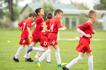 Obraz premium Kids soccer football - children players exercising before match on soccer field