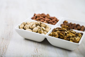 Nuts in a plate on a  wooden table.