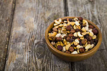 Nuts in a wooden bowl  on a  wooden table.