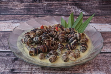 Siput Masak Lemak - Traditional Malay Cuisine. snails cook with turmeric herbs, coconut milk, spices and chilli.