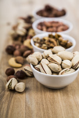 Nuts in a plate on a  wooden table.