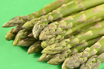 Asparagus spears on green chopping board