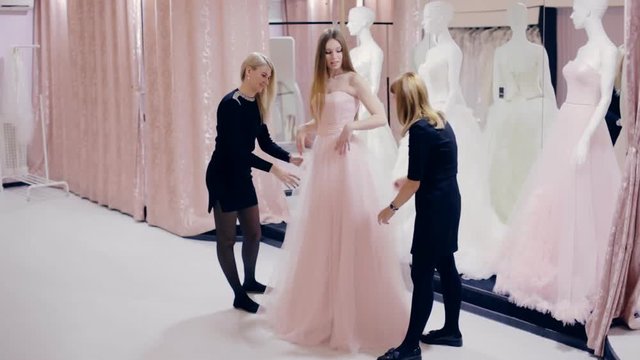 Pretty girl chooses a prom gown in boutique