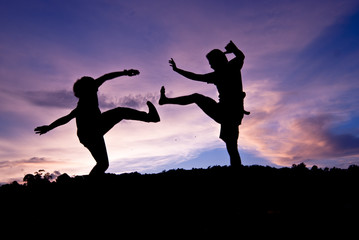 Fototapeta na wymiar Silhouette happy jumping against beautiful in sunset. Freedom, enjoyment concept