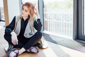 One girl pose to camera near the wall with sunlight