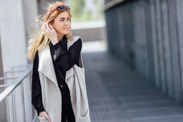 One girl pose to camera near the wall with sunlight